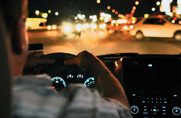 Night Driving. A photo shows a person driving at night.