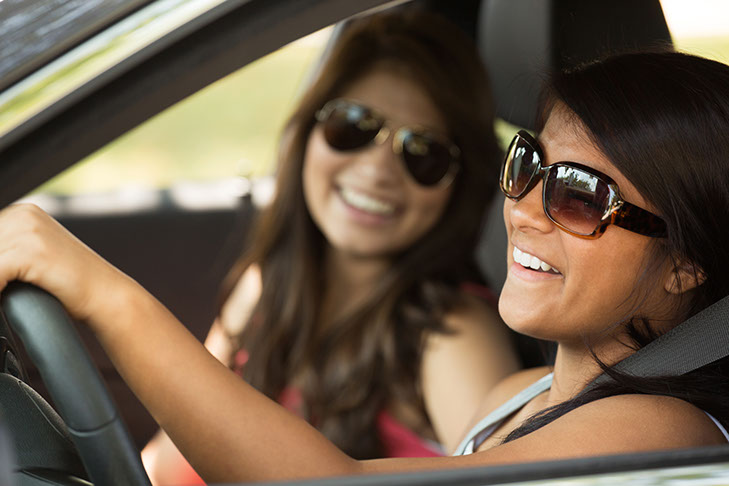 Teen Passengers. A photo shows two teenage girls talking while one drives the car.